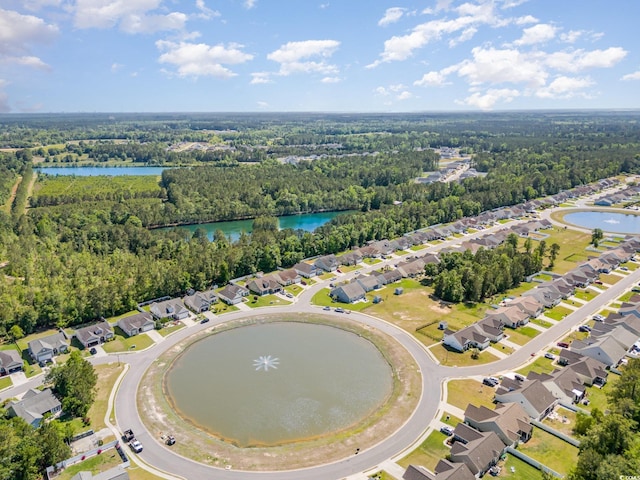 drone / aerial view with a water view, a view of trees, and a residential view