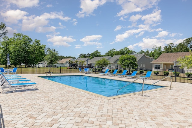 pool with fence, a residential view, and a patio area