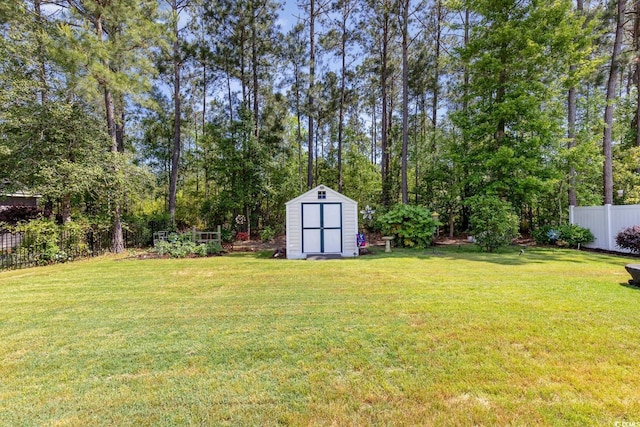 view of yard featuring a storage shed, fence, and an outdoor structure