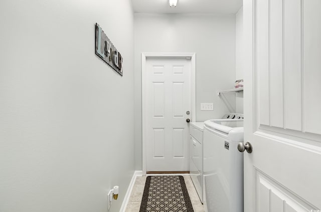 laundry area featuring separate washer and dryer, baseboards, and laundry area