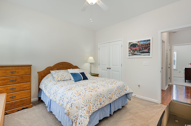 bedroom featuring baseboards, a ceiling fan, a closet, and light colored carpet