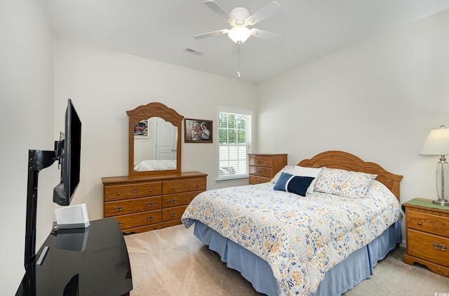 bedroom with light colored carpet, a ceiling fan, and visible vents