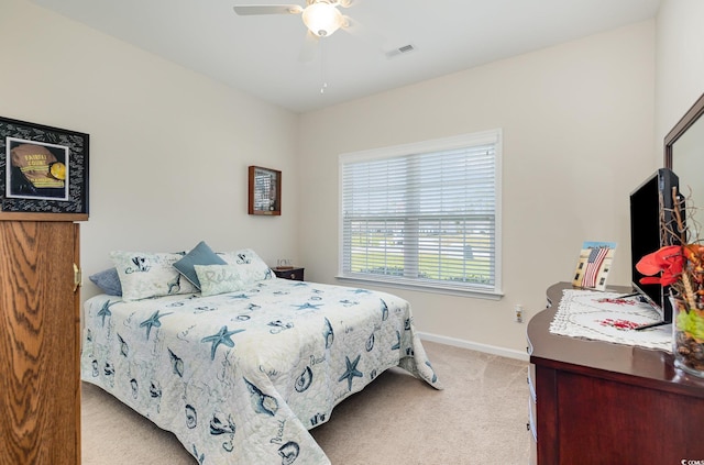 bedroom featuring visible vents, baseboards, ceiling fan, and light carpet