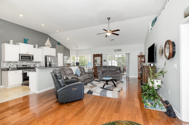living room featuring light wood-type flooring, a ceiling fan, recessed lighting, and high vaulted ceiling