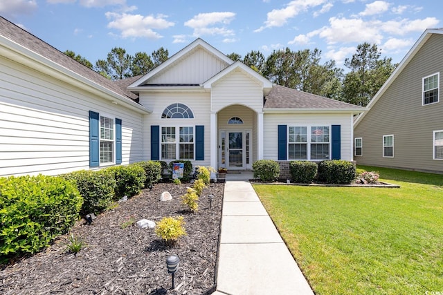 view of front of house featuring a shingled roof, board and batten siding, and a front yard