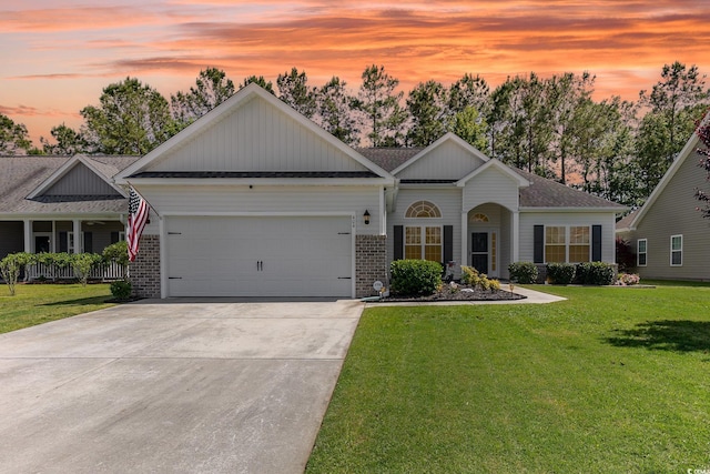ranch-style house featuring brick siding, a garage, a front yard, and concrete driveway