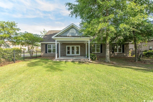 rear view of house featuring fence, a patio, french doors, brick siding, and a lawn