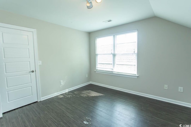 unfurnished bedroom with dark wood-style flooring, baseboards, visible vents, and lofted ceiling