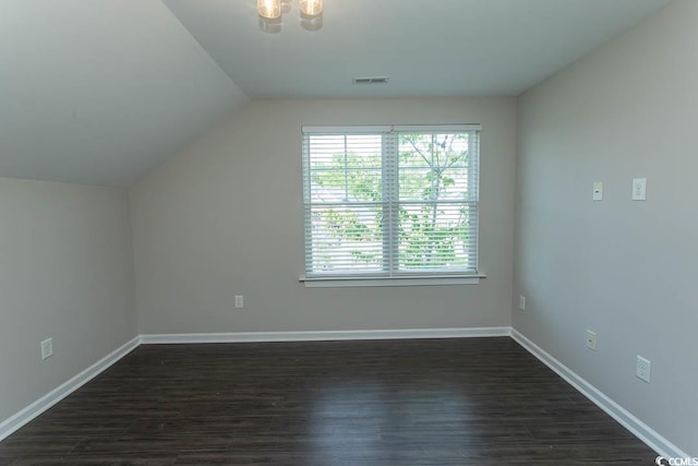 additional living space with visible vents, baseboards, dark wood-type flooring, and vaulted ceiling