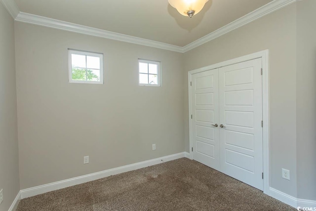 unfurnished bedroom with crown molding, baseboards, dark carpet, and a closet