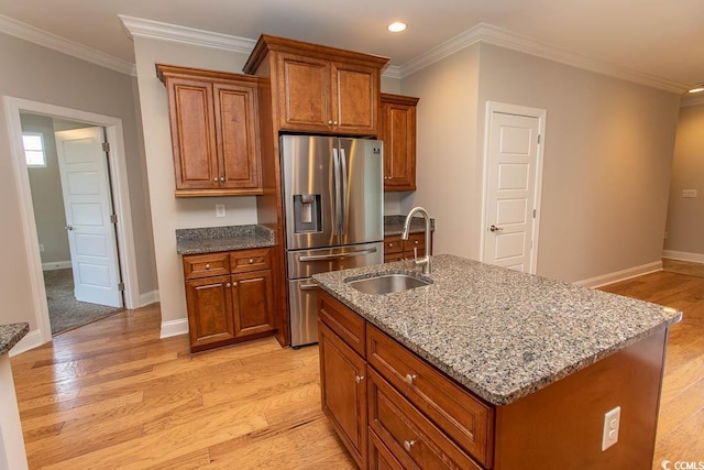 kitchen with brown cabinets, a sink, stainless steel fridge with ice dispenser, light wood-style floors, and recessed lighting