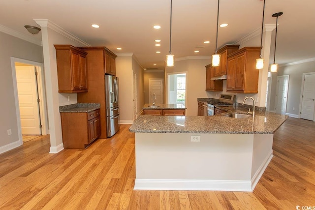 kitchen with a sink, range with gas cooktop, stainless steel refrigerator with ice dispenser, and brown cabinetry