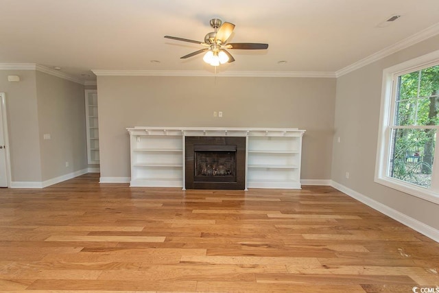 unfurnished living room with baseboards, crown molding, light wood-style flooring, and ceiling fan