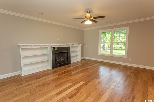 unfurnished living room with crown molding, light wood finished floors, a fireplace, a ceiling fan, and baseboards