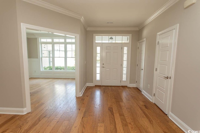 entrance foyer with light wood-type flooring, baseboards, crown molding, and visible vents