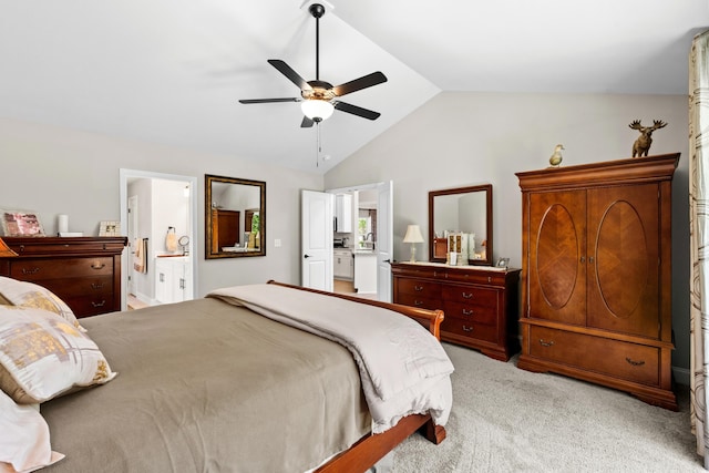 bedroom featuring vaulted ceiling, light carpet, ensuite bath, and a ceiling fan