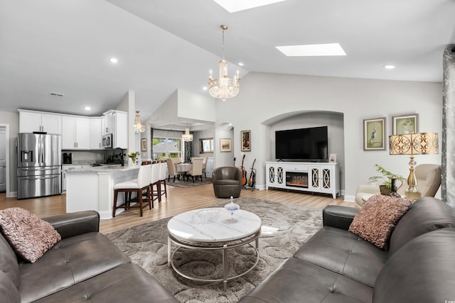 living area with light wood-style flooring, recessed lighting, visible vents, a chandelier, and a skylight