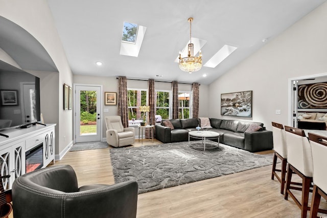 living room featuring a wealth of natural light, a skylight, and light wood-type flooring