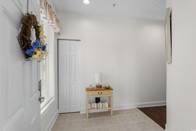 interior space featuring light tile patterned floors and baseboards
