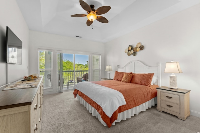 bedroom featuring visible vents, a tray ceiling, light carpet, and access to exterior