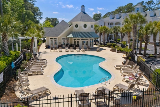 pool with a patio and fence