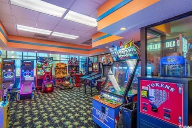 recreation room with a paneled ceiling and carpet flooring