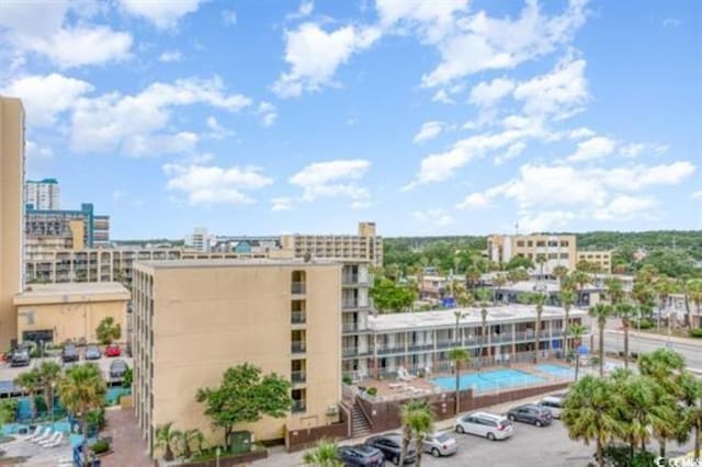 view of building exterior with uncovered parking and a city view