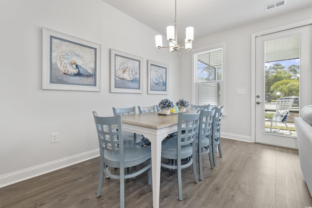 dining area featuring a chandelier, baseboards, visible vents, and wood finished floors