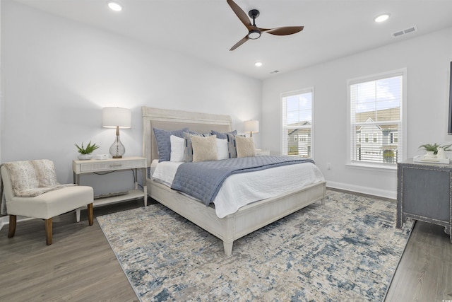 bedroom with a ceiling fan, visible vents, wood finished floors, baseboards, and recessed lighting