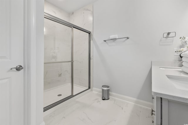 full bath with double vanity, a marble finish shower, baseboards, and marble finish floor