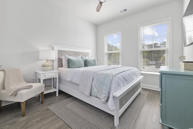 bedroom featuring baseboards, ceiling fan, wood finished floors, and visible vents
