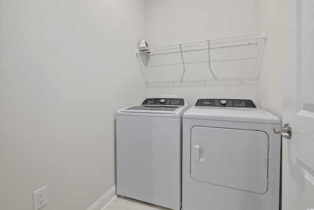 laundry room with laundry area, washing machine and dryer, and baseboards