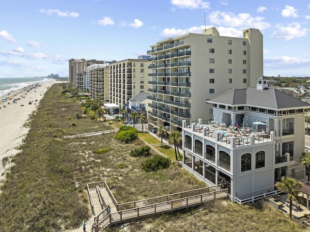 view of building exterior with a beach view and a water view