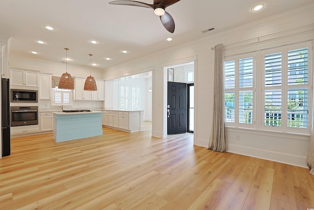 1359 Peterson St, Myrtle Beach, SC 29577 - kitchen featuring black appliances, a center island, ceiling fan, ornamental molding, and white cabinetry