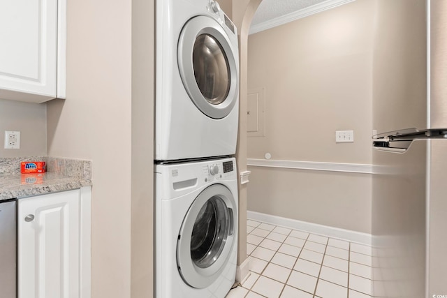 4771 Wild Iris Dr Unit 103, Myrtle Beach, SC 29577 - clothes washing area with crown molding, arched walkways, stacked washing maching and dryer, light tile patterned floors, and baseboards