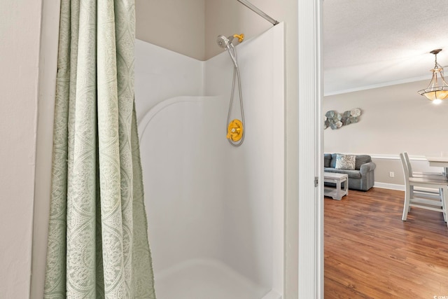 4771 Wild Iris Dr Unit 103, Myrtle Beach, SC 29577 - full bathroom with walk in shower, a textured ceiling, baseboards, wood finished floors, and ornamental molding