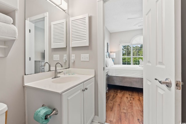 4771 Wild Iris Dr Unit 103, Myrtle Beach, SC 29577 - ensuite bathroom with vanity, wood finished floors, ceiling fan, a textured ceiling, and ensuite bath