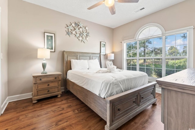 4771 Wild Iris Dr Unit 103, Myrtle Beach, SC 29577 - bedroom with dark wood-style flooring, a textured ceiling, a ceiling fan, baseboards, and visible vents