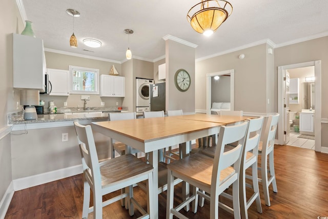 4771 Wild Iris Dr Unit 103, Myrtle Beach, SC 29577 - dining area featuring ornamental molding, stacked washer and clothes dryer, and wood finished floors