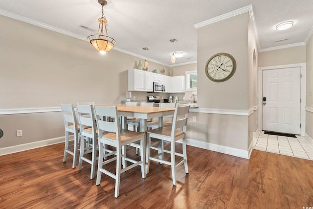4771 Wild Iris Dr Unit 103, Myrtle Beach, SC 29577 - dining space with crown molding, baseboards, and wood finished floors