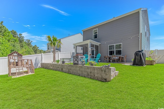 rear view of property with a fenced backyard, a patio, a yard, and a storage shed