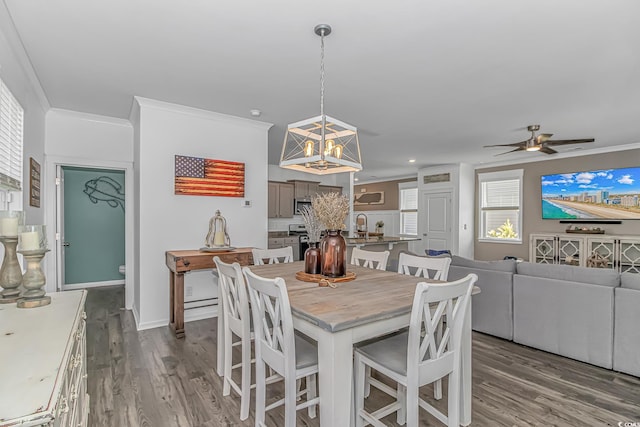 dining room featuring crown molding, recessed lighting, ceiling fan with notable chandelier, and dark wood-style floors