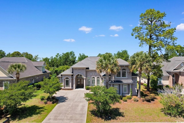 9060 Abingdon Dr, Myrtle Beach, SC 29579 - french provincial home with concrete driveway, french doors, and stucco siding