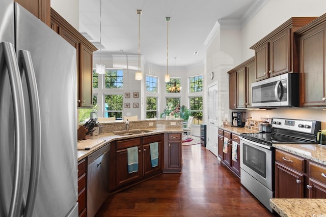 9060 Abingdon Dr, Myrtle Beach, SC 29579 - kitchen with light stone counters, a sink, dark wood finished floors, decorative light fixtures, and stainless steel appliances