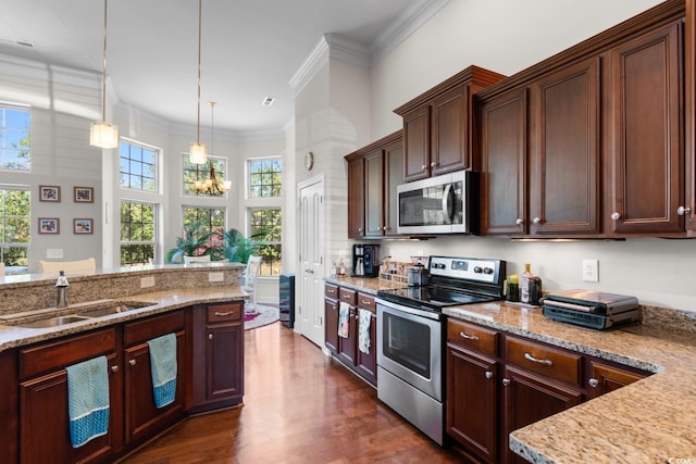 9060 Abingdon Dr, Myrtle Beach, SC 29579 - kitchen featuring decorative light fixtures, light stone countertops, dark wood finished floors, a sink, and stainless steel appliances