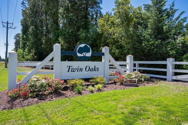 community sign with fence and a yard