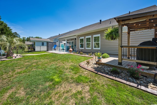 back of property with a yard, a deck, fence, and a patio