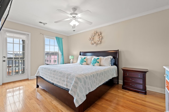 bedroom with crown molding, light wood-type flooring, and visible vents