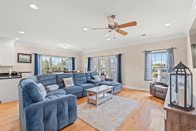 living room with visible vents, a ceiling fan, a healthy amount of sunlight, and light wood-type flooring