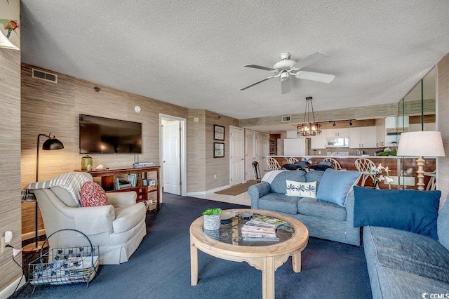 carpeted living room featuring a ceiling fan, visible vents, and a textured ceiling
